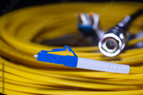 LC CONNECTOR YELLOW OFC PATCH CORD LUCENT CONNECTOR IN BLACK BACKGROUND TELE COMMUNICATION photo