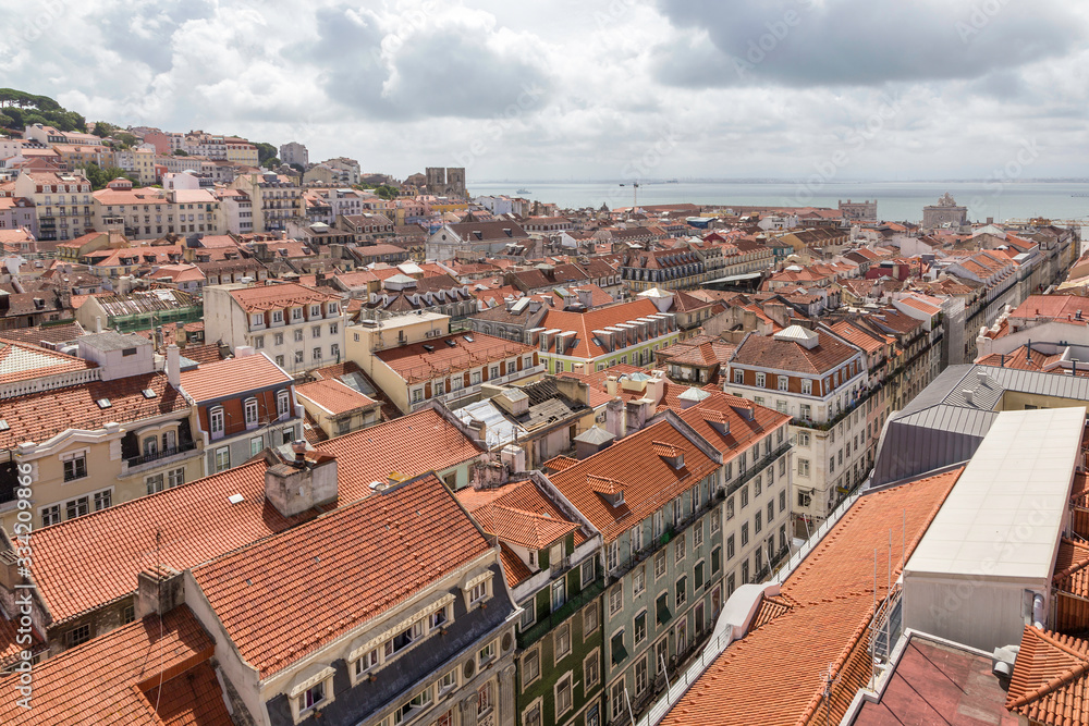Top view on Lisbon, tiled roofs of houses and the Tagus River. Lisbon, Portugal.