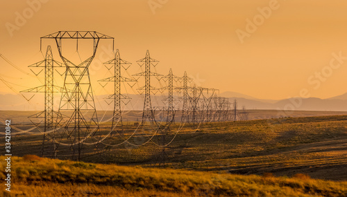 Electrical power lines through a rural landscape at sunset, USA