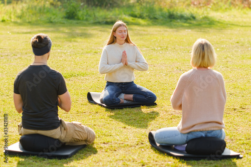 A group of young people meditate outdoors in a park.  © Oleg Samoylov