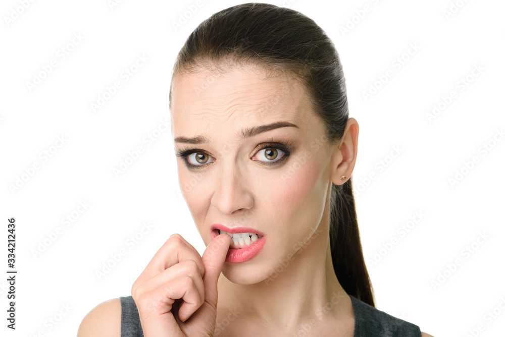 Charming confused young woman with standing and biting nails over white background Charming confused young woman with standing and biting nails over white background