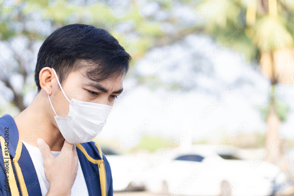 Closeup man wearing face mask for protect air polution or virus covid 19 with chest pain , health care and medical concept Closeup man wearing face mask for protect air polution or virus covid 19 with chest pain , health care and medical concept
