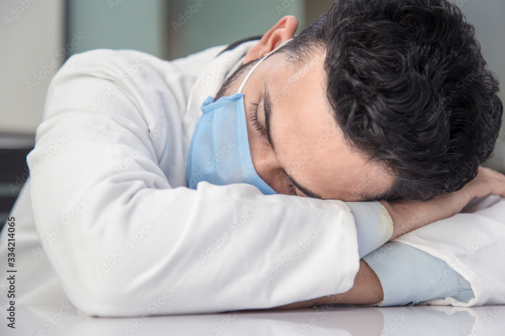 Overworked female medical professional is napping on chair in hospital Overworked female medical professional is napping on chair in hospital