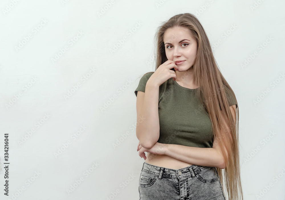 Girl with long hair looks confused, hand near face Girl with long hair looks confused, hand near face