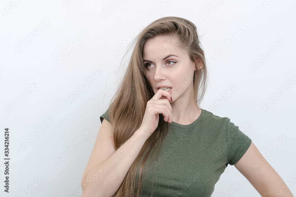 Girl with long hair looks confused, hand near face Girl with long hair looks confused, hand near face
