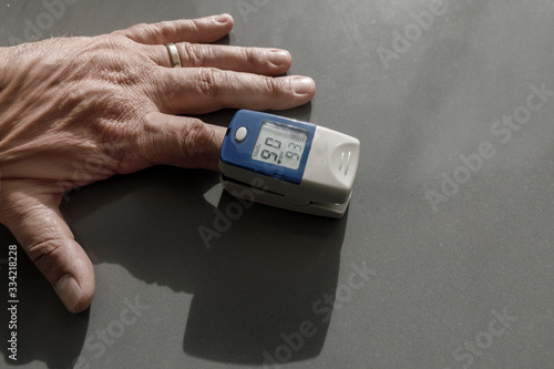 Misuratore di ossigeno da dito su una mano, su sfondo grigio photo