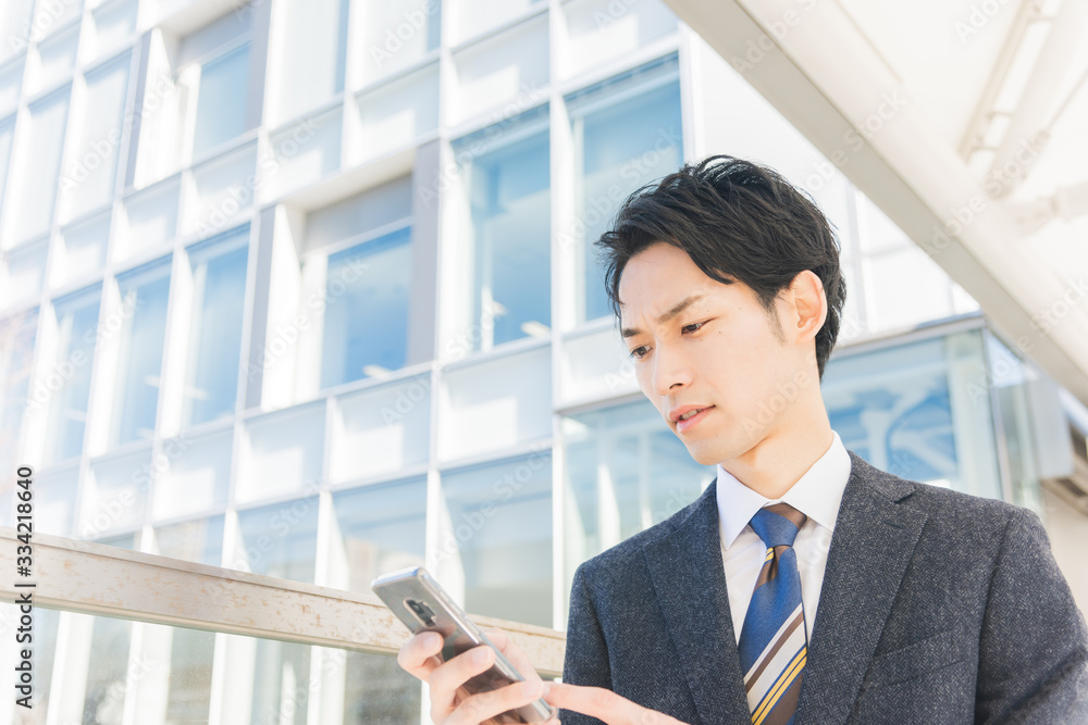 スマートフォンを手に持つビジネスマン スマートフォンを手に持つビジネスマン