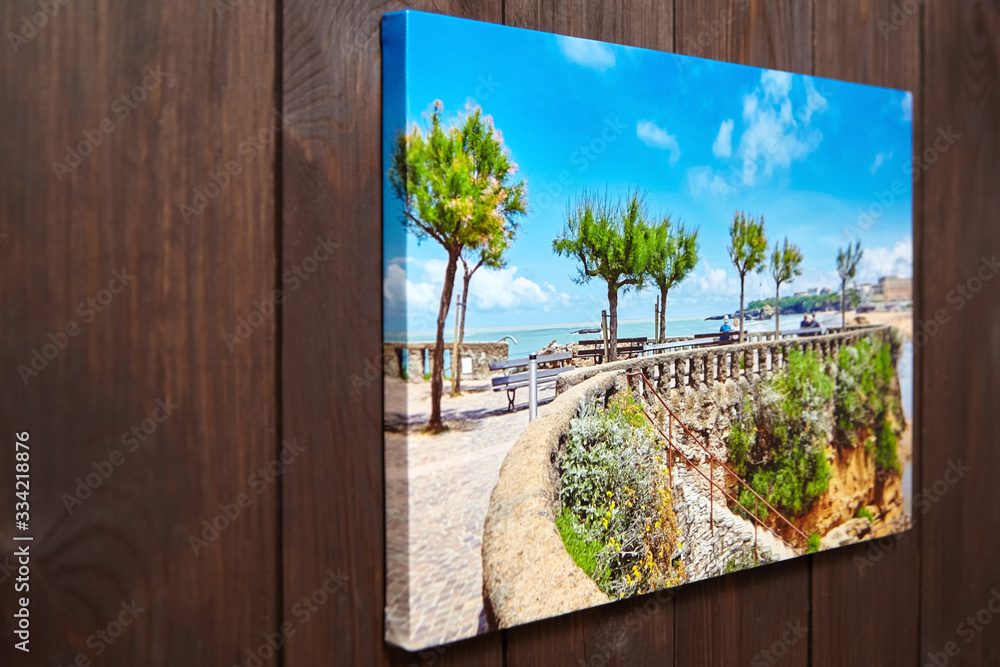 Canvas print with gallery wrap technique for mounting and stretching canvas. Wall decor. Stretched photo on brown wooden background. Photography industry