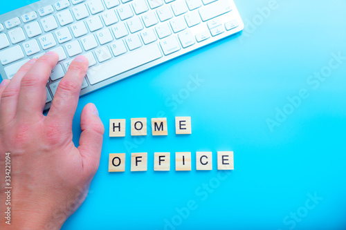 home office work from home concept with letters wooden. And keyboard  next to  background blue photo