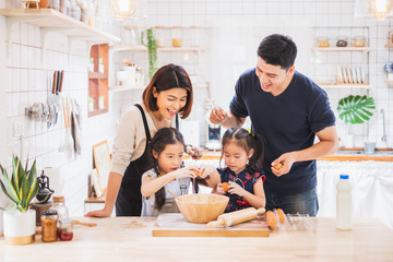 Asian family enjoy playing and cooking food in kitchen at home