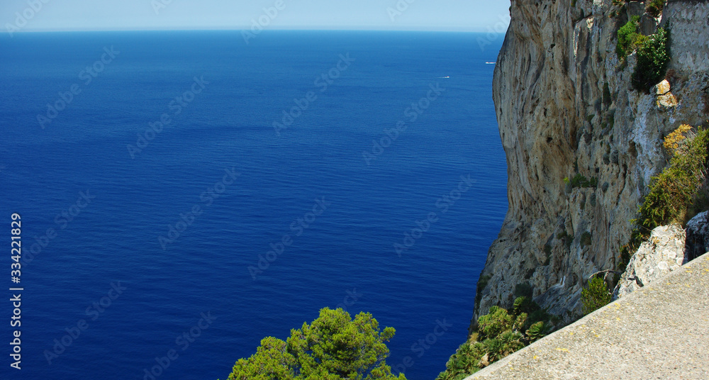 Vivid landscape of Balearic sea from the Formentor Cape, Mallorca island. Deep blue sea, rocks and foliage. Background, copyspace. Sunny day. Classic blue.