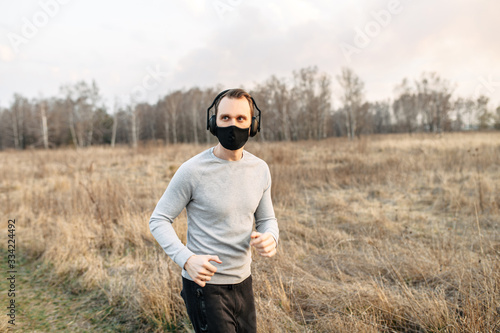 Guy in a medical mask is jogging © Vadim Pastuh