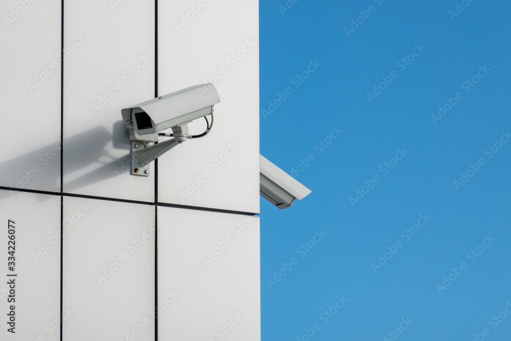 Two outdoor surveillance cameras on the facade of the building. Copy space. Two outdoor surveillance cameras on the facade of the building. Copy space.