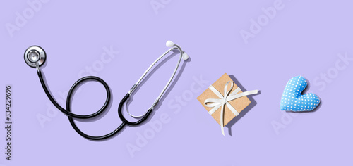 Stethoscope with a gift and a heart cushion - flat lay
