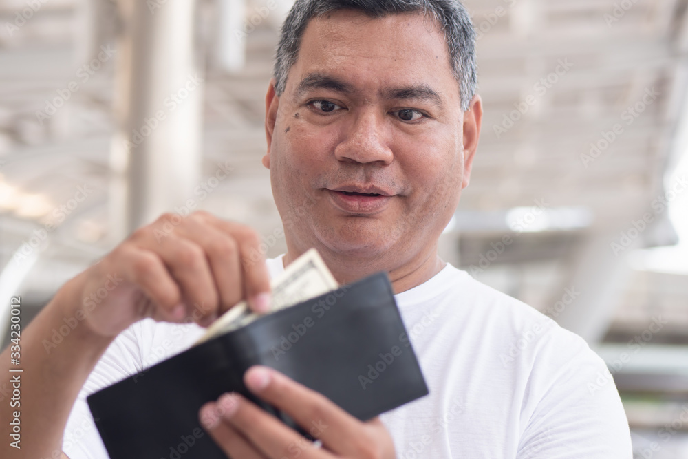 old senior man having some money in his wallet; concept of money revenue, wages, economic growth, job, employment, financial plan, expenditure, cost of living