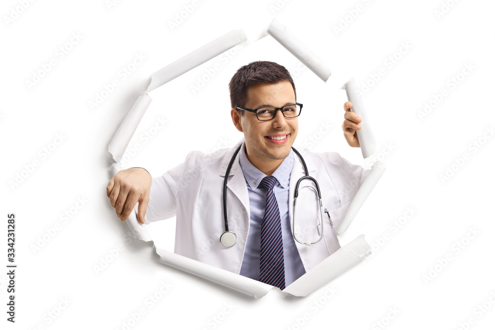 Young male doctor smiling and looking through a paper hole