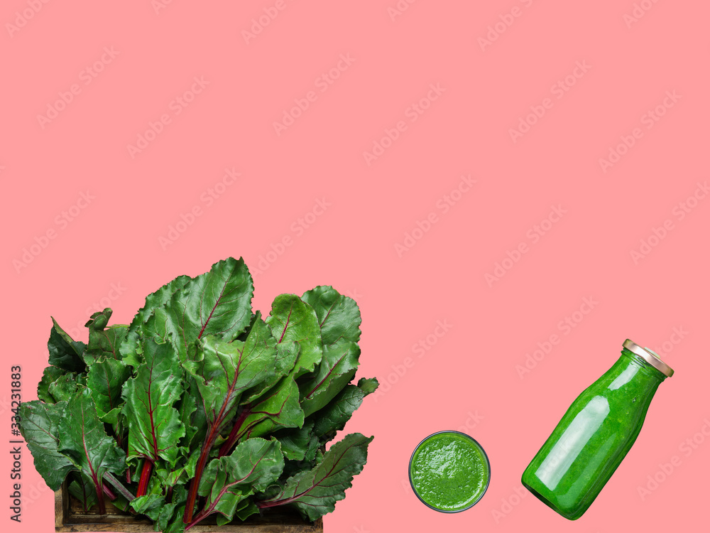 Glass bottle with fresh raw spinach leafy greens kale vegetables fruits smoothie beet root leaves on background. Healthy plant based diet immunity boosting food detox vegan concept