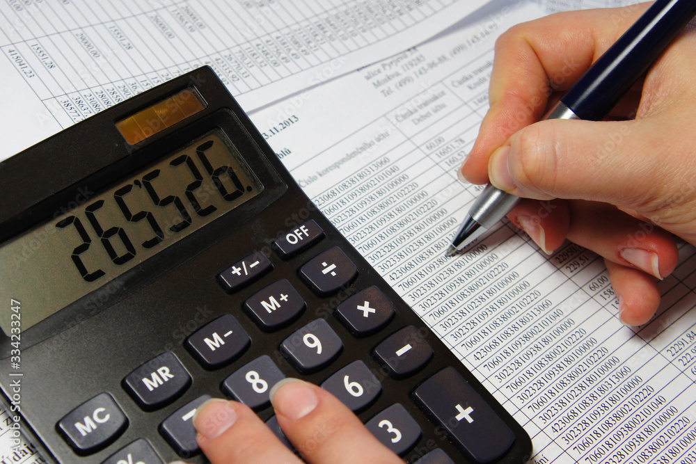 Office table with calculator, pen and accounting document Office table with calculator, pen and accounting document