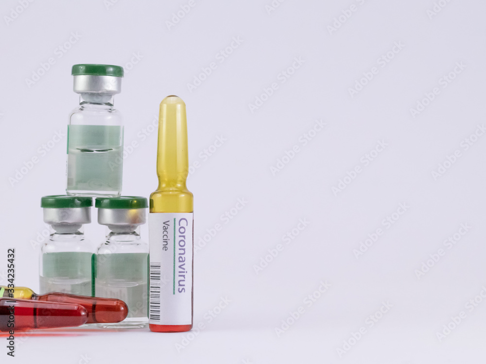 Corona Virus Vaccine label on an ampoule with another two ampoules and three vials on a white background. Corona Virus Vaccine label on an ampoule with another two ampoules and three vials on a white background.