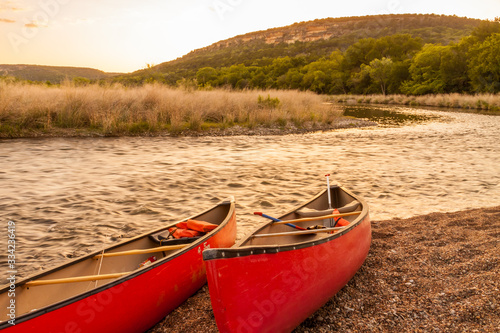Red Canoes Beside The Brazos River at Sunset, Near Palo Pinto,Texas, USA