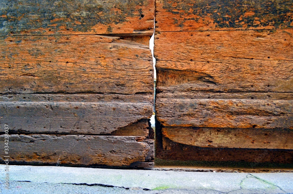 fragment of a very old wooden door with cracks and potholes fragment of a very old wooden door with cracks and potholes