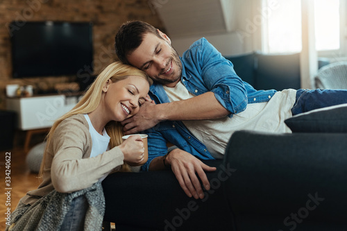 Young loving couple relaxing with eyes closed in their living room.