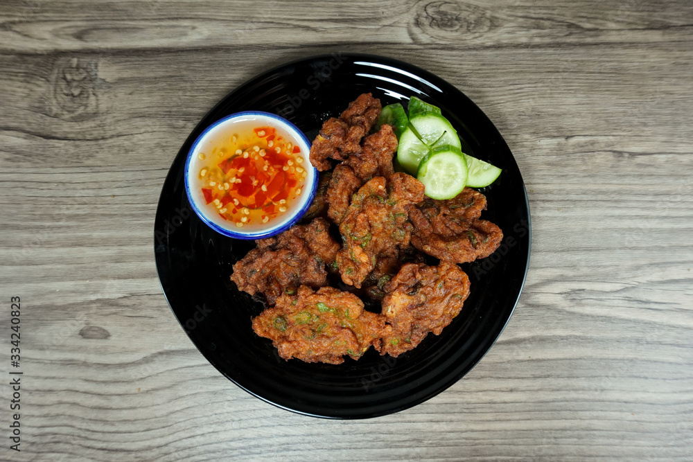 Fried fish paste balls in white plate on wooden table, Top view. Thai traditional style foods. Fried fish paste balls in white plate on wooden table, Top view. Thai traditional style foods.