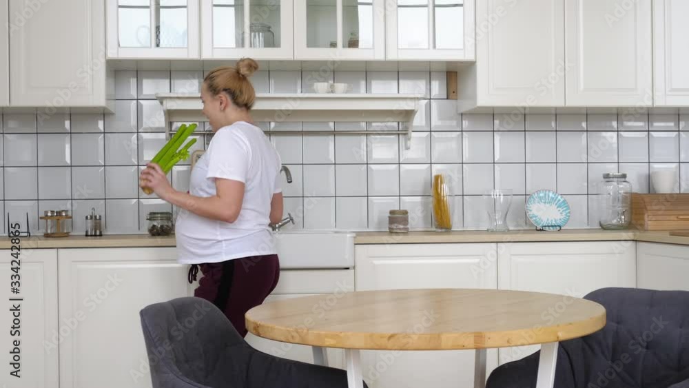 Pregnant girl dancing in the kitchen Pregnant girl dancing in the kitchen