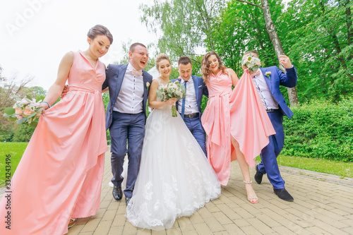 Bride and groom with best friends walk and have fun at green par © Ivan