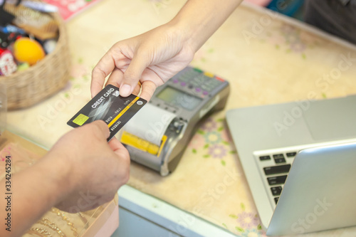 Retail, credit card payment service. Customer paying for order Product. Woman paying with card contactless in the shop store. Close-up view on the terminale and card