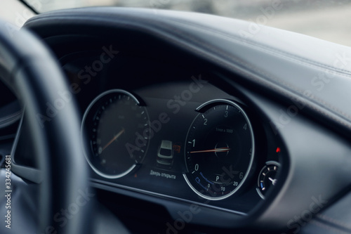 Glowing beautiful dashboard of a modern expensive car. The interior of the car. The foreground is blurred. Modern car interior details. Car detailing. Selective focus © svetlichniy_igor