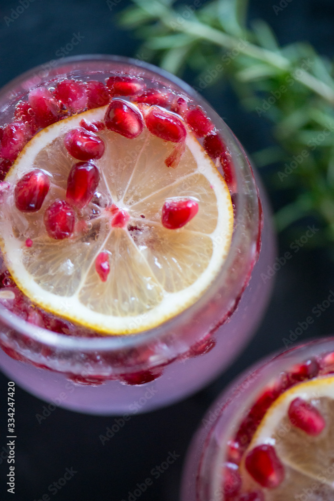 pomegranates in a lemon drink with sparkling water in a wine glass pomegranates in a lemon drink with sparkling water in a wine glass