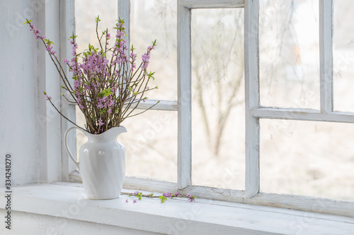 daphne flowers in vase on vintage windowsill