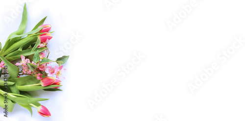 A delicate floral arrangement of pink tulips, Sakura and astromeria on a white background. Delicate colors. Background for cards, invitations, and greetings. photo