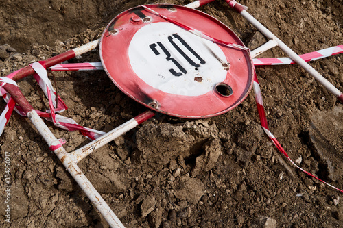 Wallpaper Mural the road sign for the speed limit of thirty kilometers or miles per hour and the road fence for performing repair work lies on the ground Torontodigital.ca