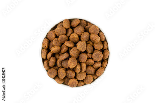 Dry pet food in round white bowl isolated on white, top view.