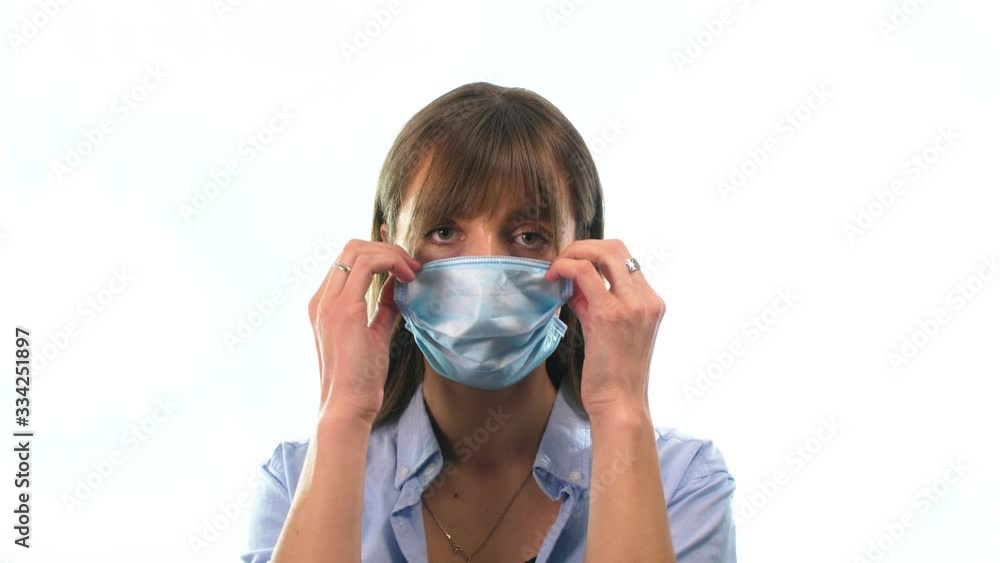girl in a shirt on an isolated white background, takes off a medical mask under which you can see the makeup of a terrible disease girl in a shirt on an isolated white background, takes off a medical mask under which you can see the makeup of a terrible disease
