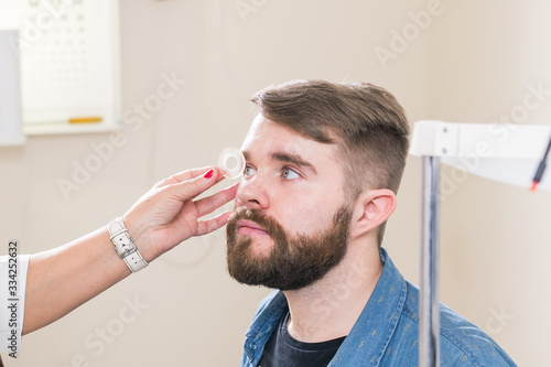 Medicine, health, ophthalmology concept - Ophthalmologist examines patient's eyes.