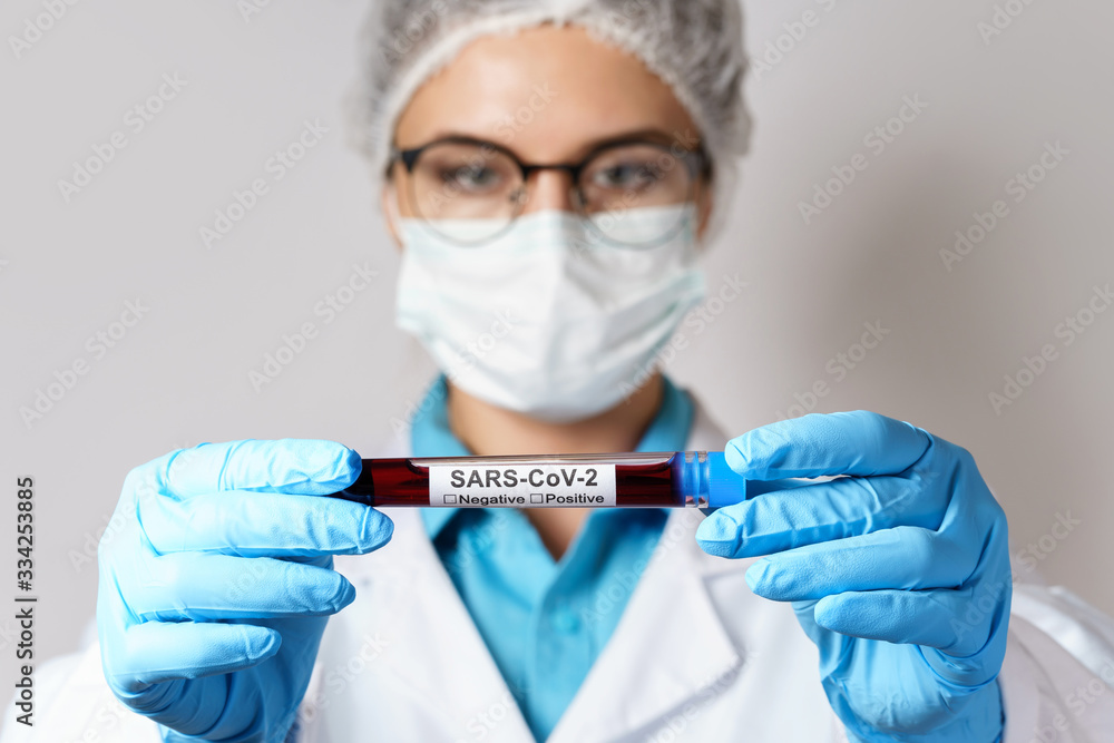 Female doctor is holding a blood sample of the SARS-CoV-2 Female doctor is holding a blood sample of the SARS-CoV-2
