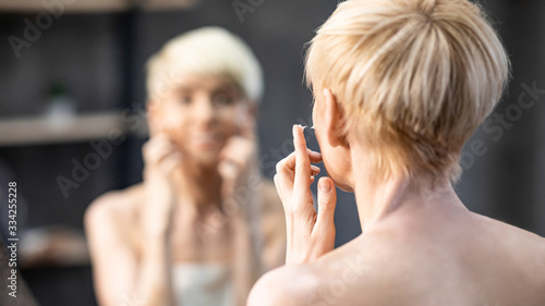Lady Applying Face Cream Preventing Skin Aging At Home, Back-View