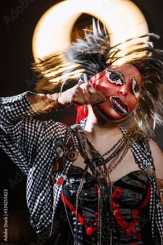A girl in chaotic clothing and a red stocking mask on her face is in a panic