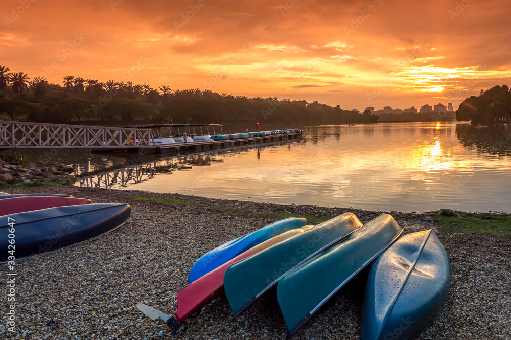 A bunch of kayaks stranded with a orange sunset background