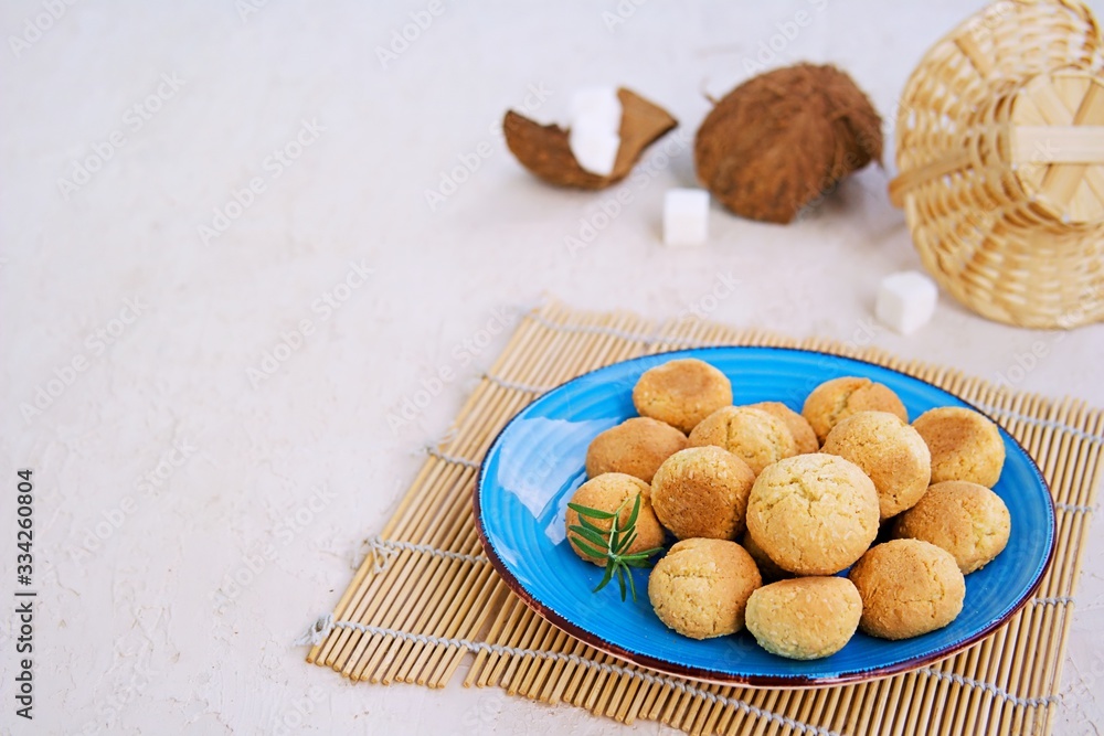 Ball-shaped sweet coconut cookies on a blue clay plate on a light concrete background. Coconut Baking Ball-shaped sweet coconut cookies on a blue clay plate on a light concrete background. Coconut Baking