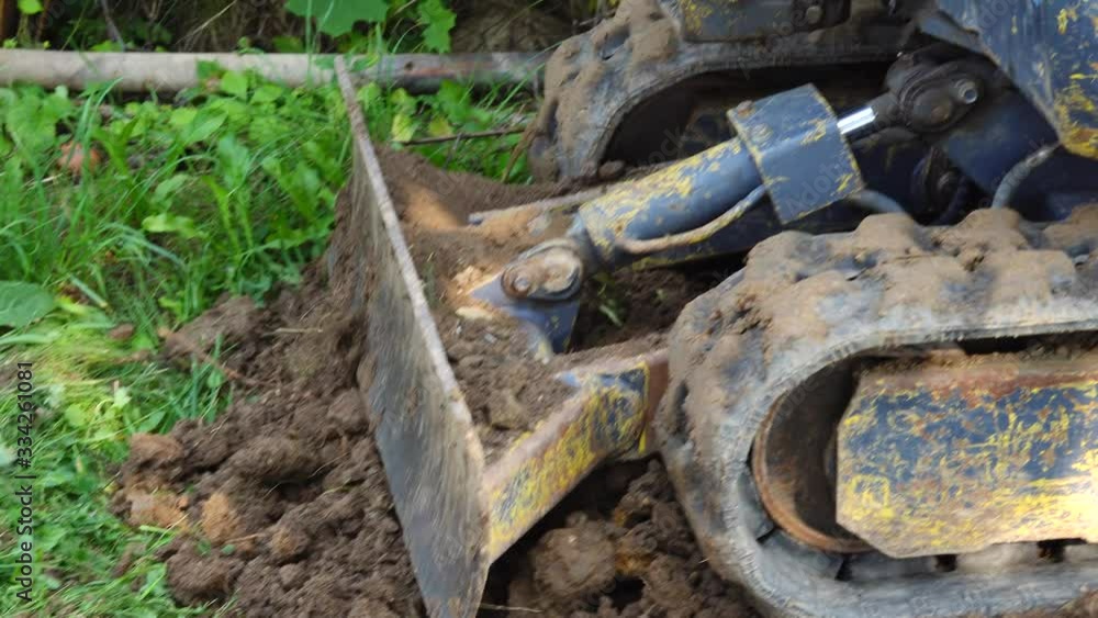 A small power shovel pushing dug out soil. A small power shovel pushing dug out soil.