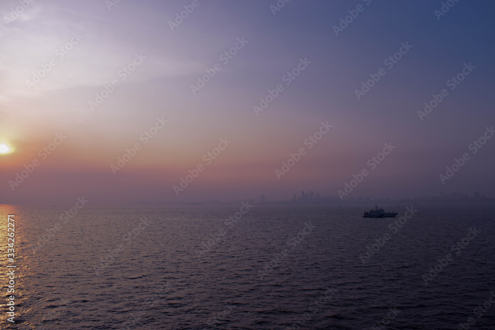 Sunset photograph shot from a cruise with a yacht against the Mumbai skyline.