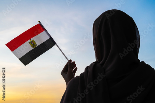 Foto Silhouette of muslim in scarf with Egyptian flag of at sunset