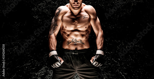 Cuadro en lienzo Mixed martial artist posing on a black background