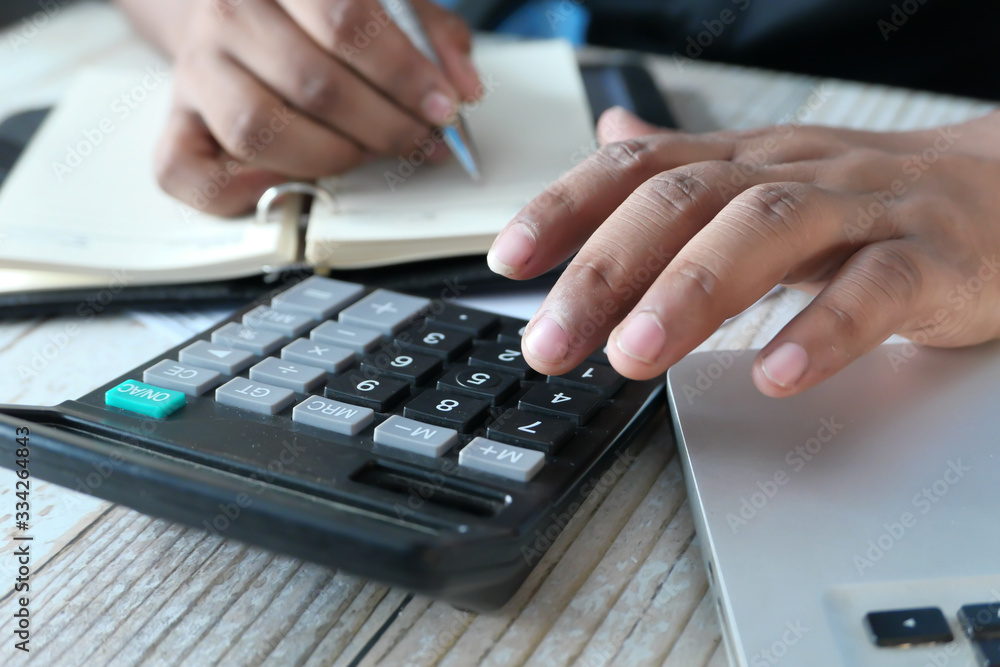 Close up of young man using calculator Close up of young man using calculator