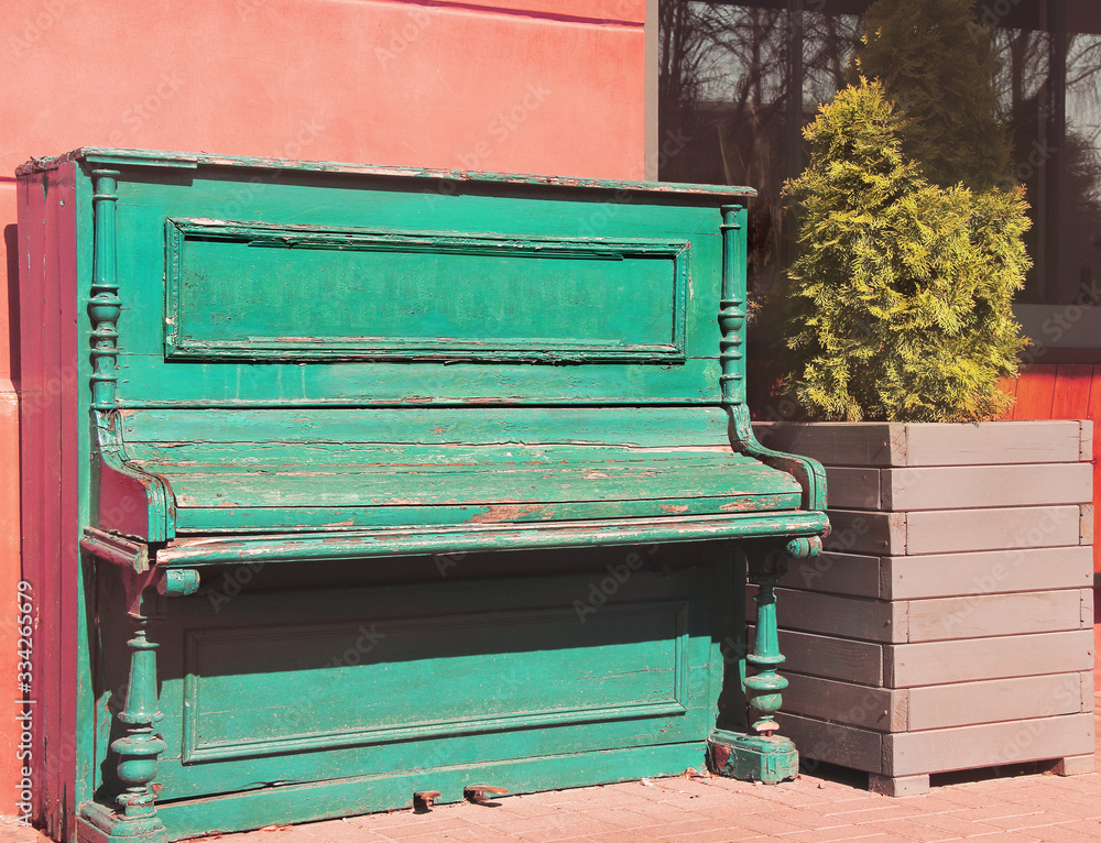 The piano on the street. Old piano near the plant The piano on the street. Old piano near the plant