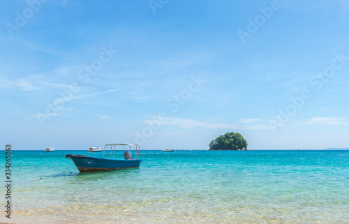 Floating boat in clear water at an island. © mawardibahar
